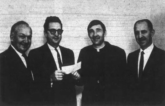Glenn Horrell (second from left) presents a check to Father Edwin Hustedde, president of Gibault High School, to open the booster club drive for funds, November 1969 (Waterloo Republican)
