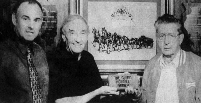 Gibault's Father Ed Hustedde hands Glenn Horrell a memorial brick, part of the "Renewing Our Story" campaign, November 1997 (Clarion Journal)