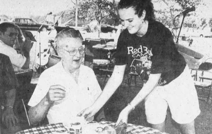 Glenn Horrell receives a slice of cake from BAC student Stephanie Kieffer during a celebration of Belleville Area College's 50th anniversary, September 1996 (Clarion Journal)
